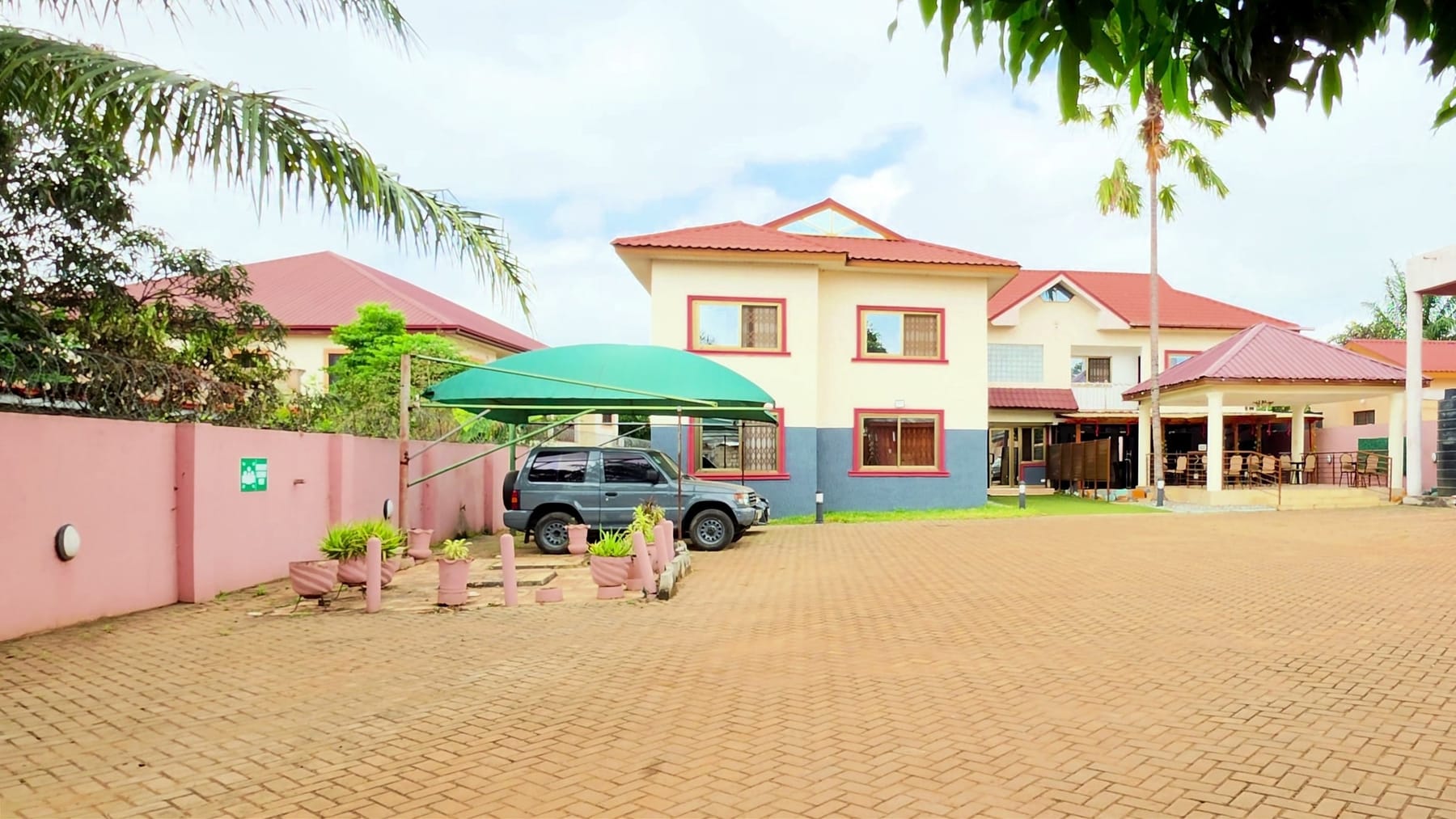 Restall Guest Lodge by day, from the paved compound inside the gate