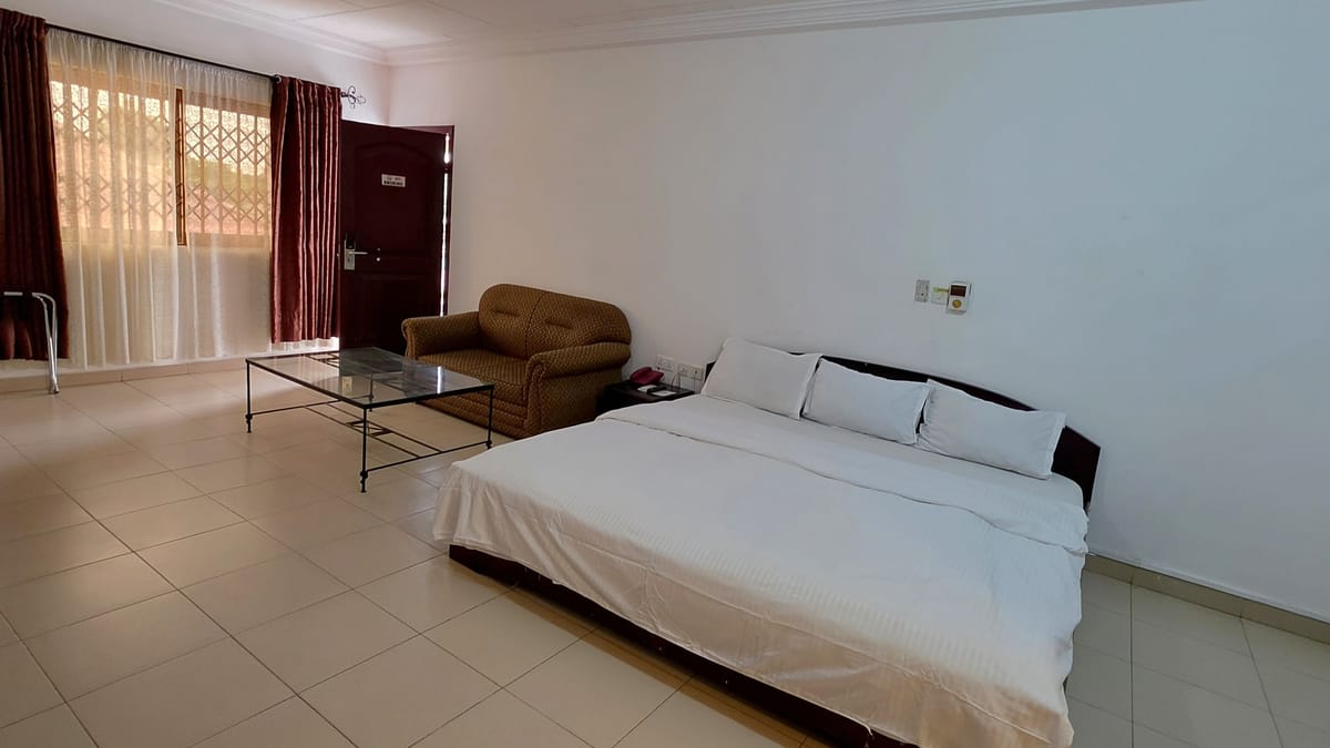 The Super Executive Room: a large bed, a sofa and glass table by the window