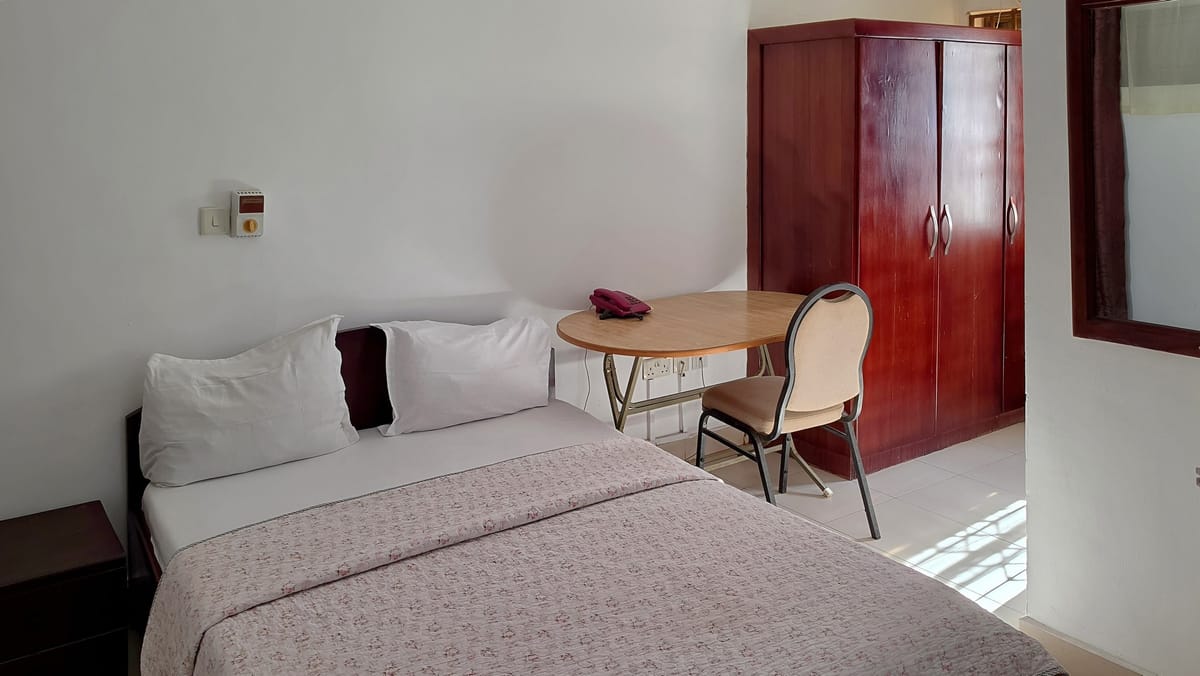 The Budget Room: a double bed, a small table and chair, and a wardrobe