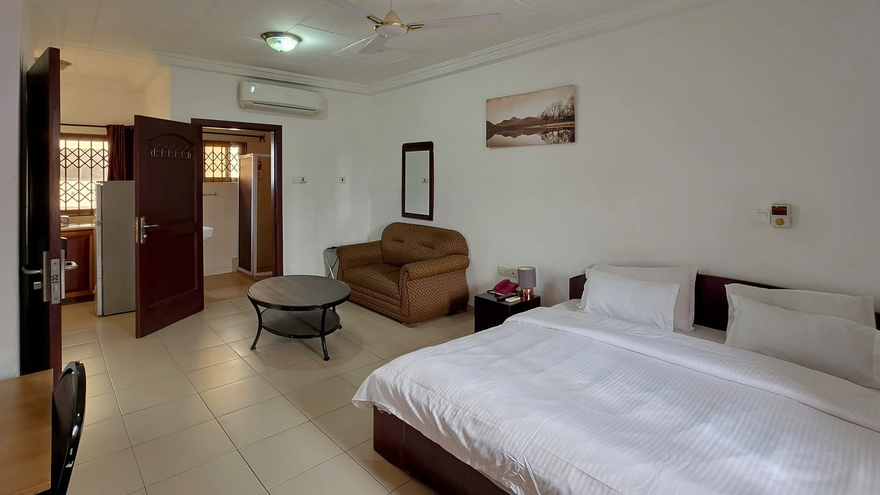 A guest room with a large bed and a sitting area
